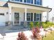 Charming home featuring a covered front porch with stone accents, complemented by manicured landscaping at 1311 Arena Ln, Fuquay Varina, NC 27526