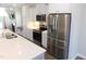 Modern kitchen featuring white cabinets, stainless steel appliances, and sleek countertops and island at 1311 Arena Ln, Fuquay Varina, NC 27526
