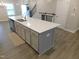 Spacious kitchen island with stainless steel sink and modern grey cabinetry at 1311 Arena Ln, Fuquay Varina, NC 27526
