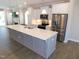 Modern kitchen featuring a large island, stainless steel appliances, and white cabinetry at 1311 Arena Ln, Fuquay Varina, NC 27526