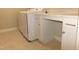 Bright laundry room featuring white washer and dryer and built in desk space with ample cabinets at 1311 Arena Ln, Fuquay Varina, NC 27526