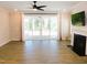 Bright living room featuring light wood floors, a ceiling fan, a fireplace, and a patio exit at 1311 Arena Ln, Fuquay Varina, NC 27526