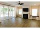 Bright living room features a fireplace, tv, ceiling fan, and sliding glass doors to outdoor patio at 1311 Arena Ln, Fuquay Varina, NC 27526