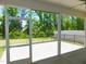 This screened porch features white framework, a concrete floor, and a view of the home's green backyard at 1311 Arena Ln, Fuquay Varina, NC 27526