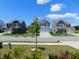 A street view showcasing well-maintained homes with manicured lawns and mature trees on a sunny day at 1311 Arena Ln, Fuquay Varina, NC 27526