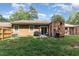 Backyard featuring a patio with grill, chairs, sliding glass door, surrounded by green lawn and trees at 139 Hollyhock Ct, Durham, NC 27713