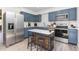 Modern kitchen with blue cabinets, stainless steel appliances, a marble island with stools, and ample counter space at 139 Hollyhock Ct, Durham, NC 27713