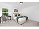 This bedroom features a large window, neutral carpet, and a desk adjacent to the bed at 140 Summer Mist Ln # 159, Clayton, NC 27527