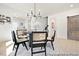 Bright dining area features a modern chandelier, round table, and stylish black chairs with woven backs at 140 Summer Mist Ln # 159, Clayton, NC 27527