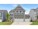 Charming two-story home featuring a three car garage, manicured lawn, and modern architectural details at 140 Summer Mist Ln # 159, Clayton, NC 27527