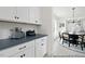 Kitchen space featuring white cabinets with black hardware and a view into the dining area at 140 Summer Mist Ln # 159, Clayton, NC 27527