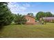 The home's grassy backyard features a concrete patio, grill, and brick exterior at 1416 Chestnut St, Roxboro, NC 27573