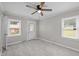 A well lit bedroom with neutral paint, windows and ceiling fan at 1416 Chestnut St, Roxboro, NC 27573