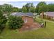 A view of a single-story brick home with a patio area and a grill, complemented by well-maintained landscaping at 1416 Chestnut St, Roxboro, NC 27573