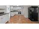 Bright kitchen boasts white cabinets, stainless steel oven, and wood-look flooring at 1416 Chestnut St, Roxboro, NC 27573