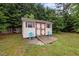 A backyard shed with double doors and a ramp, offering ample storage space and easy access for outdoor equipment at 1416 Chestnut St, Roxboro, NC 27573