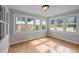 Bright sunroom with abundant natural light, wood-look flooring and neutral paint at 1416 Chestnut St, Roxboro, NC 27573