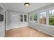 Bright sunroom with abundant natural light, wood-look flooring and neutral paint at 1416 Chestnut St, Roxboro, NC 27573