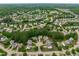 Aerial view showcases a neighborhood surrounded by lush greenery and mature trees at 1514 Hinchliff Ct, Fuquay Varina, NC 27526