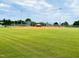 Well-maintained baseball field with green grass and fenced-in dugouts, ready for games and practice at 1514 Hinchliff Ct, Fuquay Varina, NC 27526