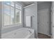 Bathroom bathtub with white shutters, neutral walls and a white door at 1514 Hinchliff Ct, Fuquay Varina, NC 27526