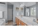 Bathroom features a dual sink vanity, large mirror, bathtub, and light blue walls at 1514 Hinchliff Ct, Fuquay Varina, NC 27526