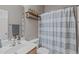 Well-lit bathroom featuring a sink, toilet and shower with striped curtain at 1514 Hinchliff Ct, Fuquay Varina, NC 27526