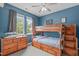 Blue bedroom with dark wood bunk bed, dresser, a ceiling fan, and gray curtains at 1514 Hinchliff Ct, Fuquay Varina, NC 27526