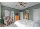 View of bedroom features a green accent wall, ceiling fan, carpet, and lots of natural light at 1514 Hinchliff Ct, Fuquay Varina, NC 27526