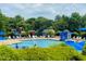 Community swimming pool with lounge chairs, umbrellas, and a slide, surrounded by lush greenery at 1514 Hinchliff Ct, Fuquay Varina, NC 27526
