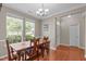 Bright dining room boasts hardwood floors, two windows, a light fixture and seating for four at 1514 Hinchliff Ct, Fuquay Varina, NC 27526