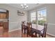 Bright dining room featuring hardwood floors, natural light, and an adjacent kitchen at 1514 Hinchliff Ct, Fuquay Varina, NC 27526