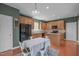 Eat-in kitchen boasts wooden cabinetry, modern appliances, and stylish dining set for cozy meals at 1514 Hinchliff Ct, Fuquay Varina, NC 27526