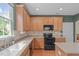 Well-appointed kitchen with stainless steel appliances, oak cabinets, and a tiled backsplash at 1514 Hinchliff Ct, Fuquay Varina, NC 27526