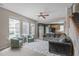 Bright, open living room with plush seating and abundant natural light from large windows and ceiling fan at 1514 Hinchliff Ct, Fuquay Varina, NC 27526