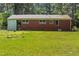View of the brick back of the house with large backyard surrounded by trees at 1709 Whitfield Ave, Rocky Mount, NC 27801