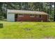 View of the brick back of the house with large backyard surrounded by greenery at 1709 Whitfield Ave, Rocky Mount, NC 27801