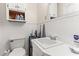 Compact bathroom with white tile, a sink, a toilet, and a small storage unit at 1709 Whitfield Ave, Rocky Mount, NC 27801