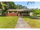Charming brick home featuring a covered porch, mature trees, and a well-manicured lawn at 1709 Whitfield Ave, Rocky Mount, NC 27801