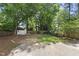 A spacious backyard that features lush green grass, mature trees, a shed and a privacy fence at 1812 Hilton St, Raleigh, NC 27608