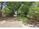 A spacious backyard that features lush green grass, mature trees, a shed and a privacy fence at 1812 Hilton St, Raleigh, NC 27608