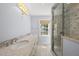 Bathroom featuring double vanity with stone countertop and glass enclosed shower with marble tile surround at 1812 Hilton St, Raleigh, NC 27608