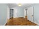 Bedroom featuring blue walls, hardwood floors and view to laundry room and hallway at 1812 Hilton St, Raleigh, NC 27608