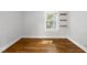 Bedroom with hardwood floors, white walls, large window and minimalist shelves at 1812 Hilton St, Raleigh, NC 27608