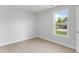 A bright bedroom with neutral carpet, double window with green backyard view, and light gray walls at 1900 Fishamble St # 17, Fuquay Varina, NC 27526
