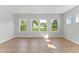 Light-filled living room with three large windows and hardwood floors at 1900 Fishamble St # 17, Fuquay Varina, NC 27526