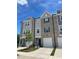 Modern townhome featuring brick and gray siding, garage, and well-maintained landscaping under a bright blue sky at 1924 Fishamble # 23, Fuquay Varina, NC 27526