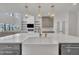 Kitchen features a white farmhouse sink, gold fixtures, gray cabinets, and a view into the living room at 2004 Yamacraw Dr, Knightdale, NC 27545