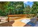 A wood deck overlooks a backyard with a rocker and an outdoor rug at 203 Worsham Dr., Chapel Hill, NC 27516