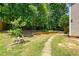 Spacious backyard with a stone path leading through lush green grass and mature trees at 203 Worsham Dr., Chapel Hill, NC 27516